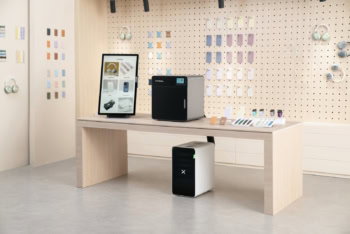 Kiosk xTool na ladę obok grawerki laserowej i oczyszczacza powietrza w sklepie z akcesoriami do telefonów